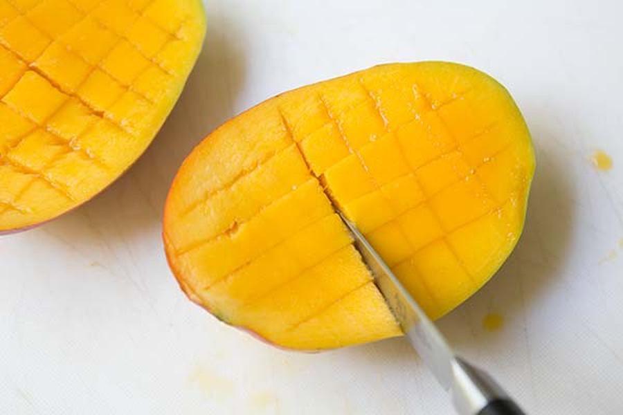 Как правильно разделать манго. Разделать манго. Нарезанное дольками манго с кожурой. Ложка для манго. Разделать манго фото.